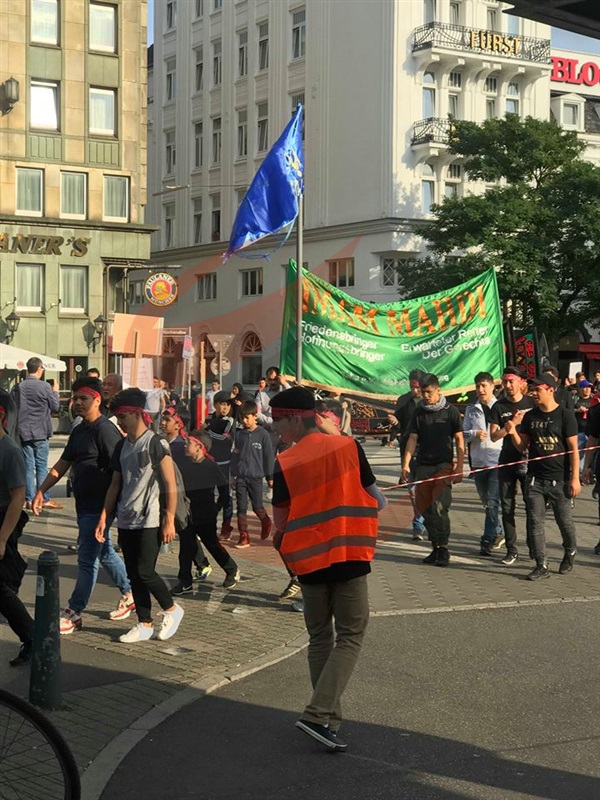 Shiitische Männer und Frauen demonstrieren in schwarz auf den Straßen von Hamburg